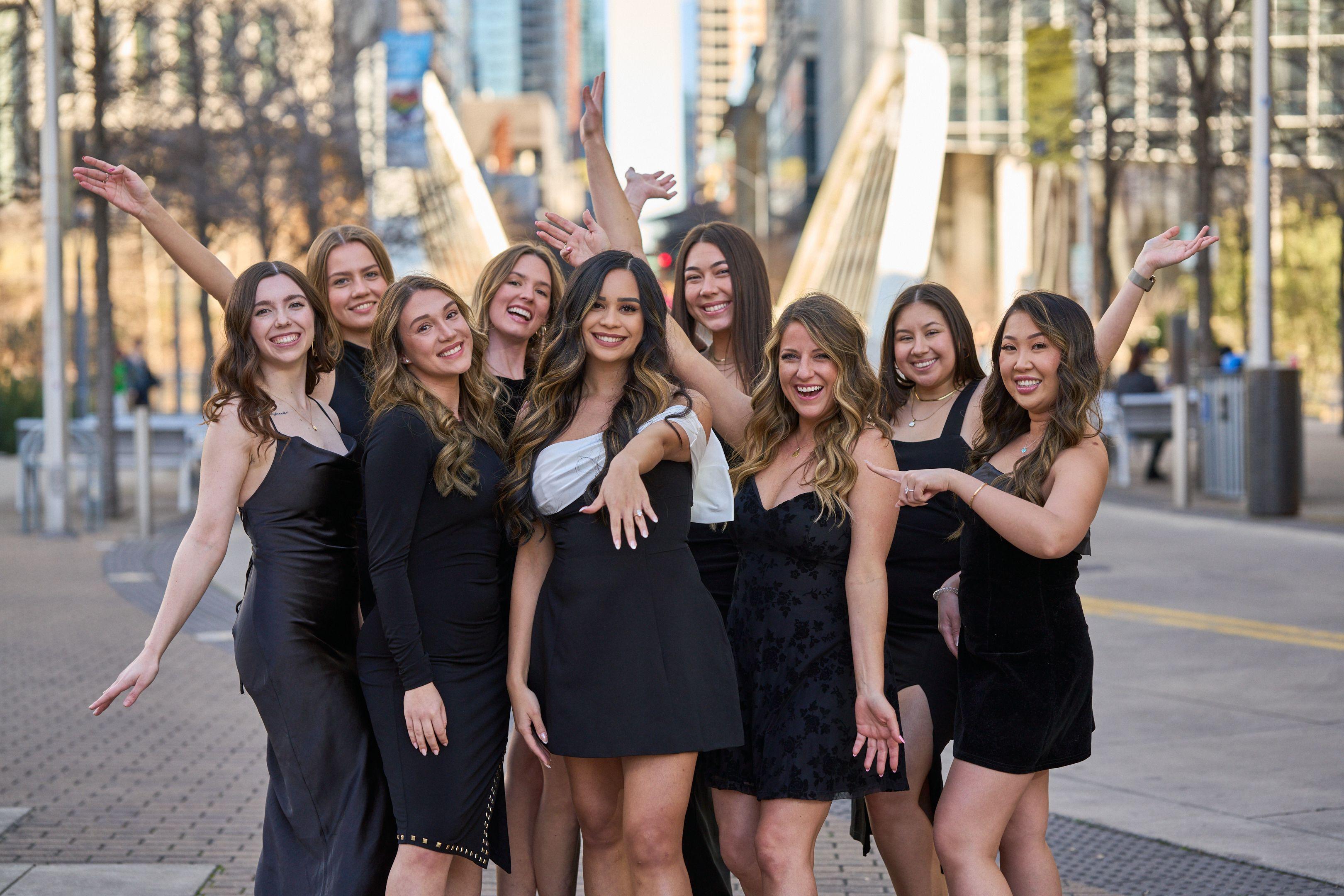 Bachelorette group in black dresses laughing, one throwing her arms up, downtown — Bachelor & Bachelorette photography, Austin A bachelorette group in black dresses laughing, one throwing her arms up, downtown behind.