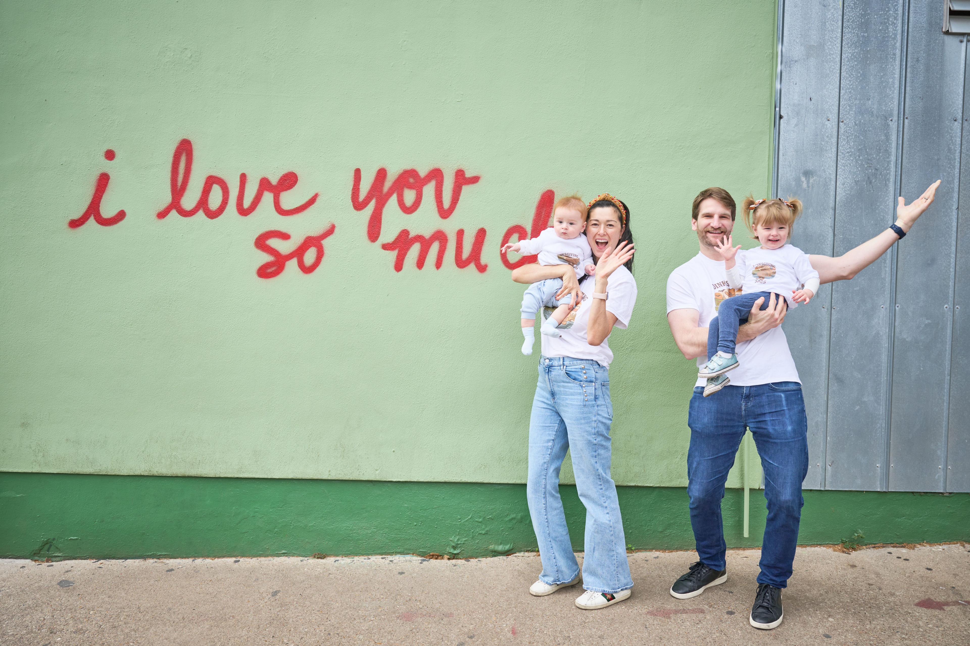 Family of three with their baby in front of the 'i love you so much' mural on South Congress — Family Portraits photography, Austin A family of three with their baby in front of the 'i love you so much' mural on South Congress.