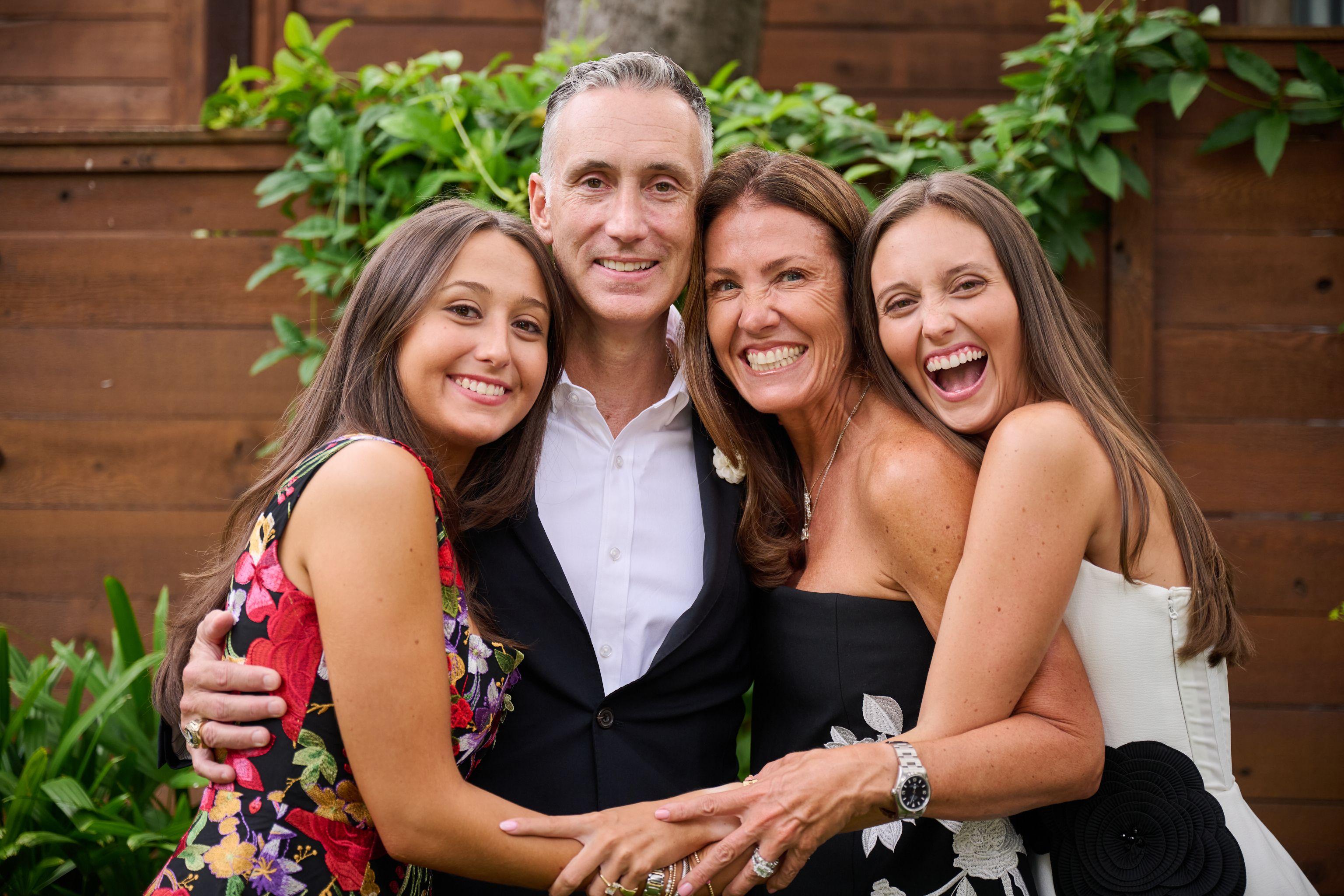 Father and three young women in party dresses hugging and laughing together — Formal Celebrations photography, Austin A father and three young women in party dresses hugging and laughing together.