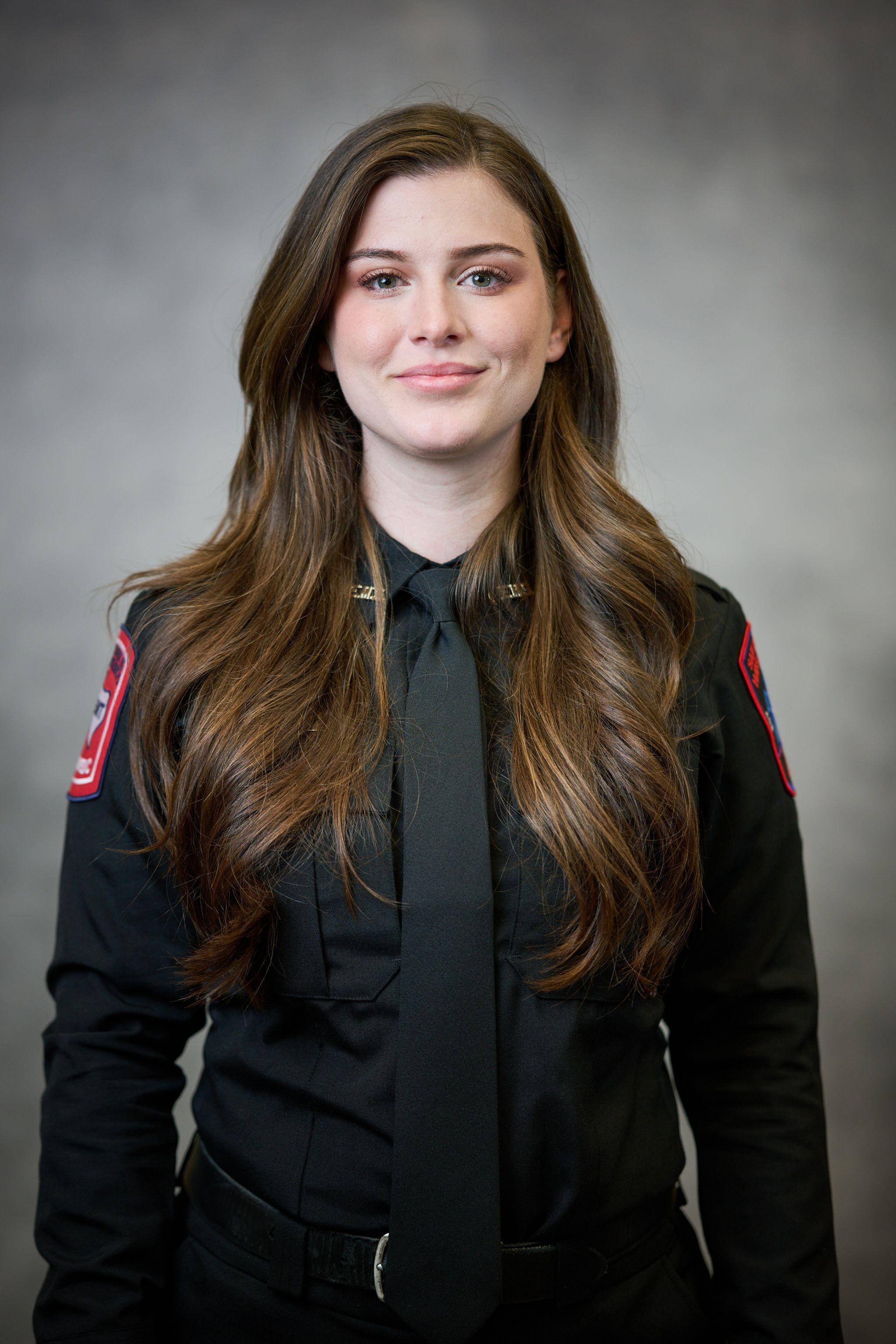Woman in a dark emergency services uniform photographed against a dark background — Business headshots, Austin A woman in a dark emergency services uniform photographed against a dark background
