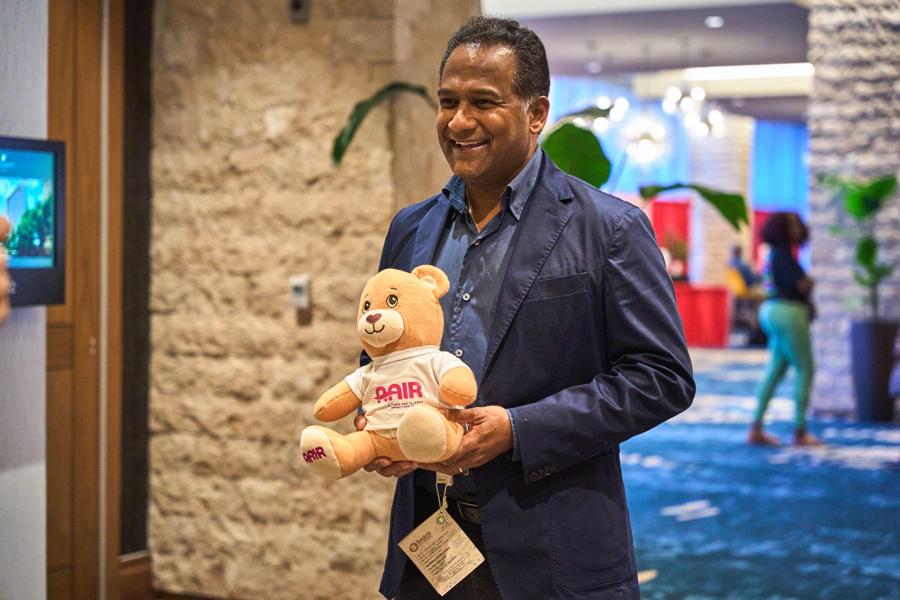 Delegate holding a branded AAIR teddy bear at a nonprofit conference — Conventions & Tradeshows photography, Austin A delegate holding a branded AAIR teddy bear at a nonprofit conference.