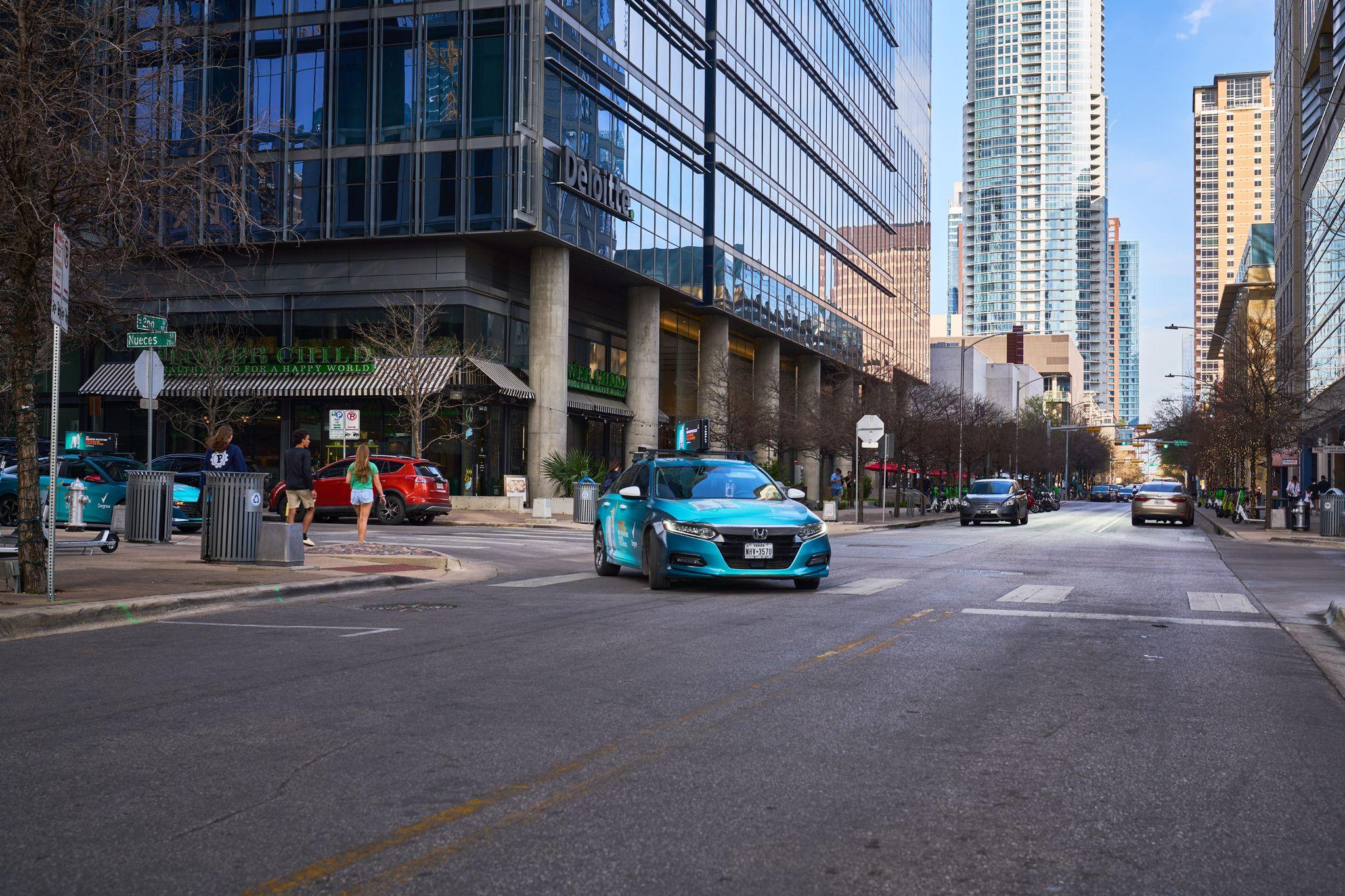 Teal sports car on an empty downtown Austin street between glass towers — Downtown Austin photography, Austin A teal sports car on an empty downtown Austin street between glass towers.