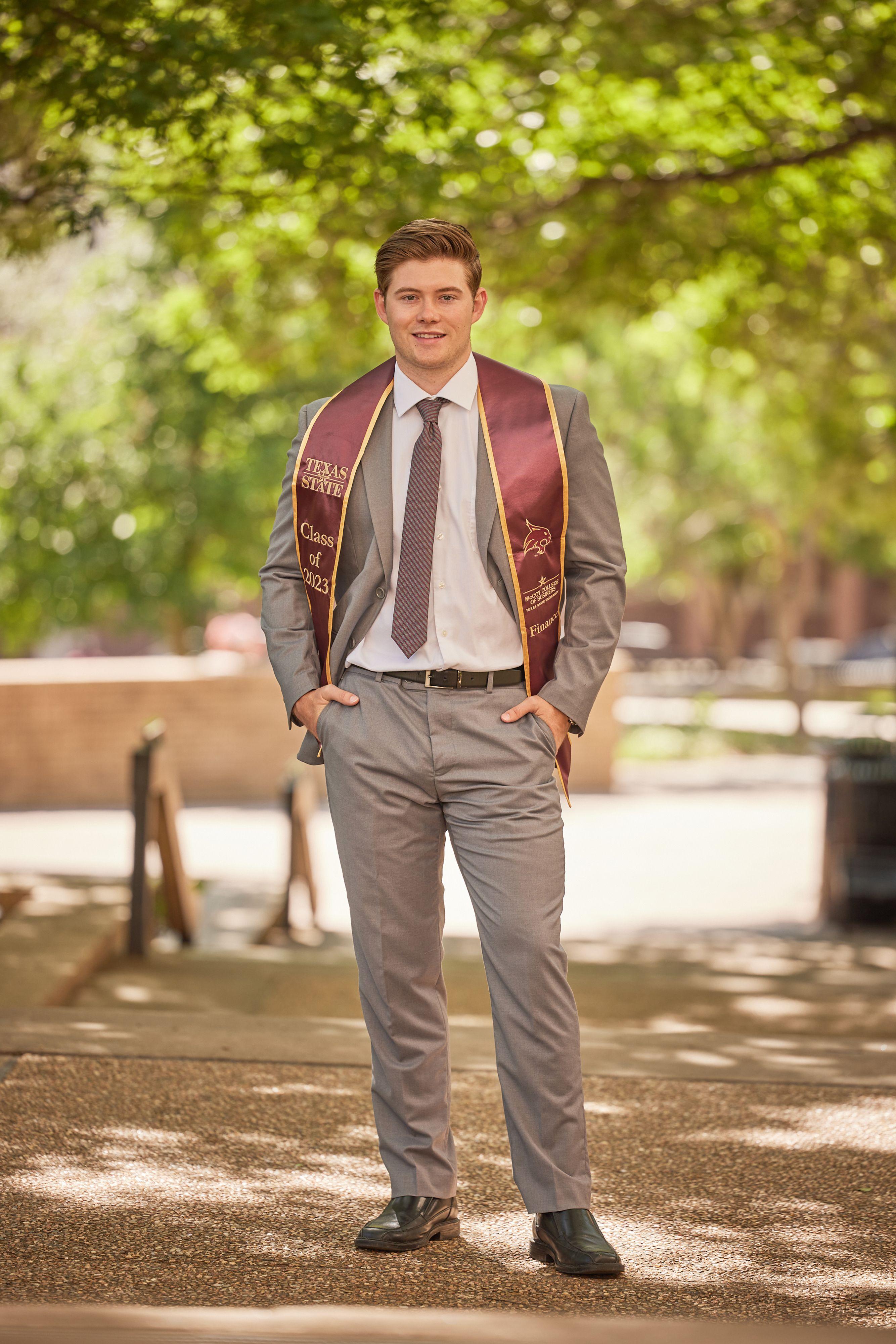 Graduate in a gray suit and maroon stole standing on the Texas State campus — Texas State University photography, Austin A graduate in a gray suit and maroon stole standing on the Texas State campus