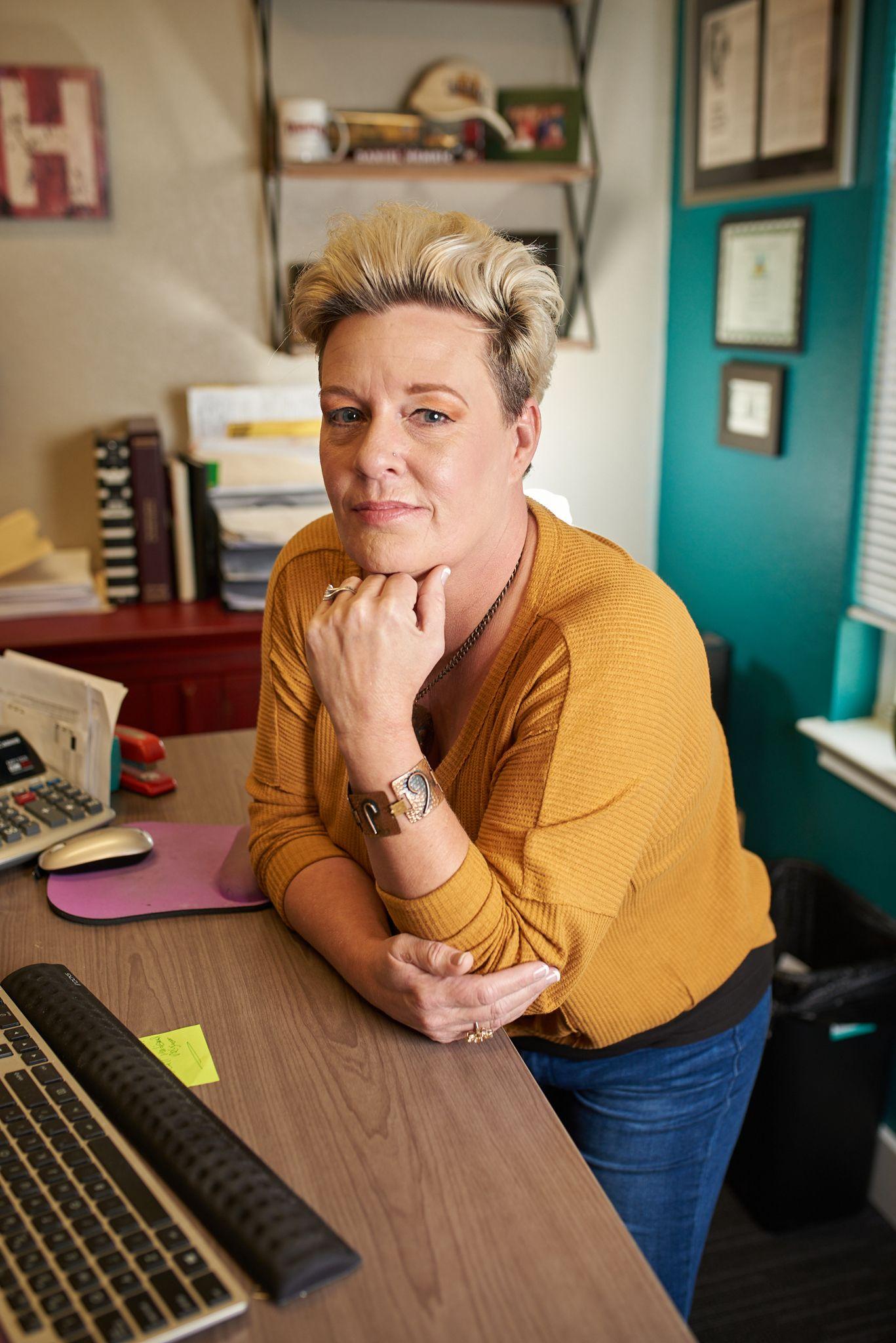 Woman leaning on a counter in her office, smiling at the camera — Portrait photography, Austin A woman leaning on a counter in her office, smiling at the camera.