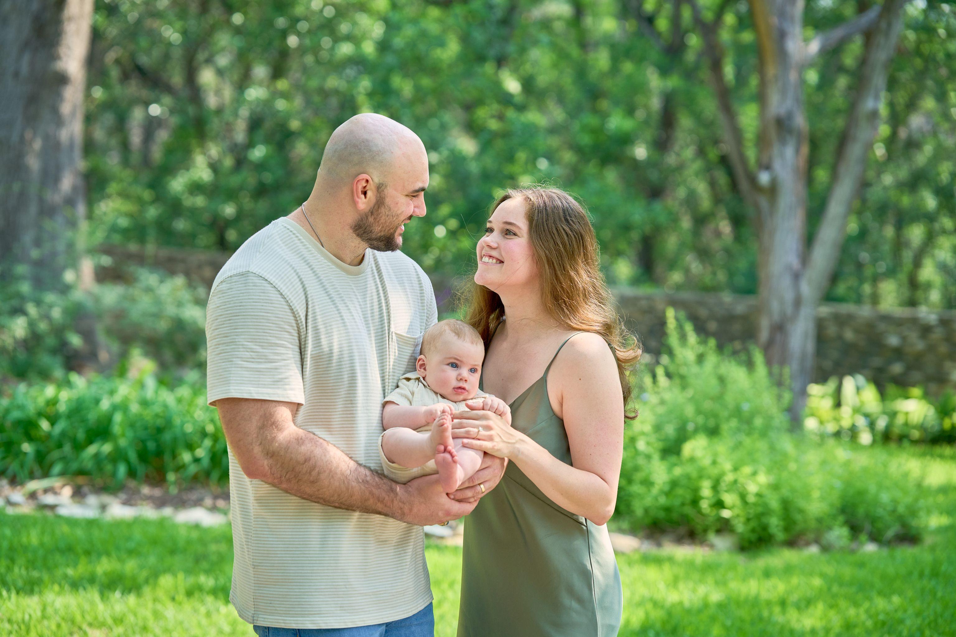 Parents holding their baby between them in the greenery at Mayfield Park — Mayfield Park photography, Austin Parents holding their baby between them in the greenery at Mayfield Park