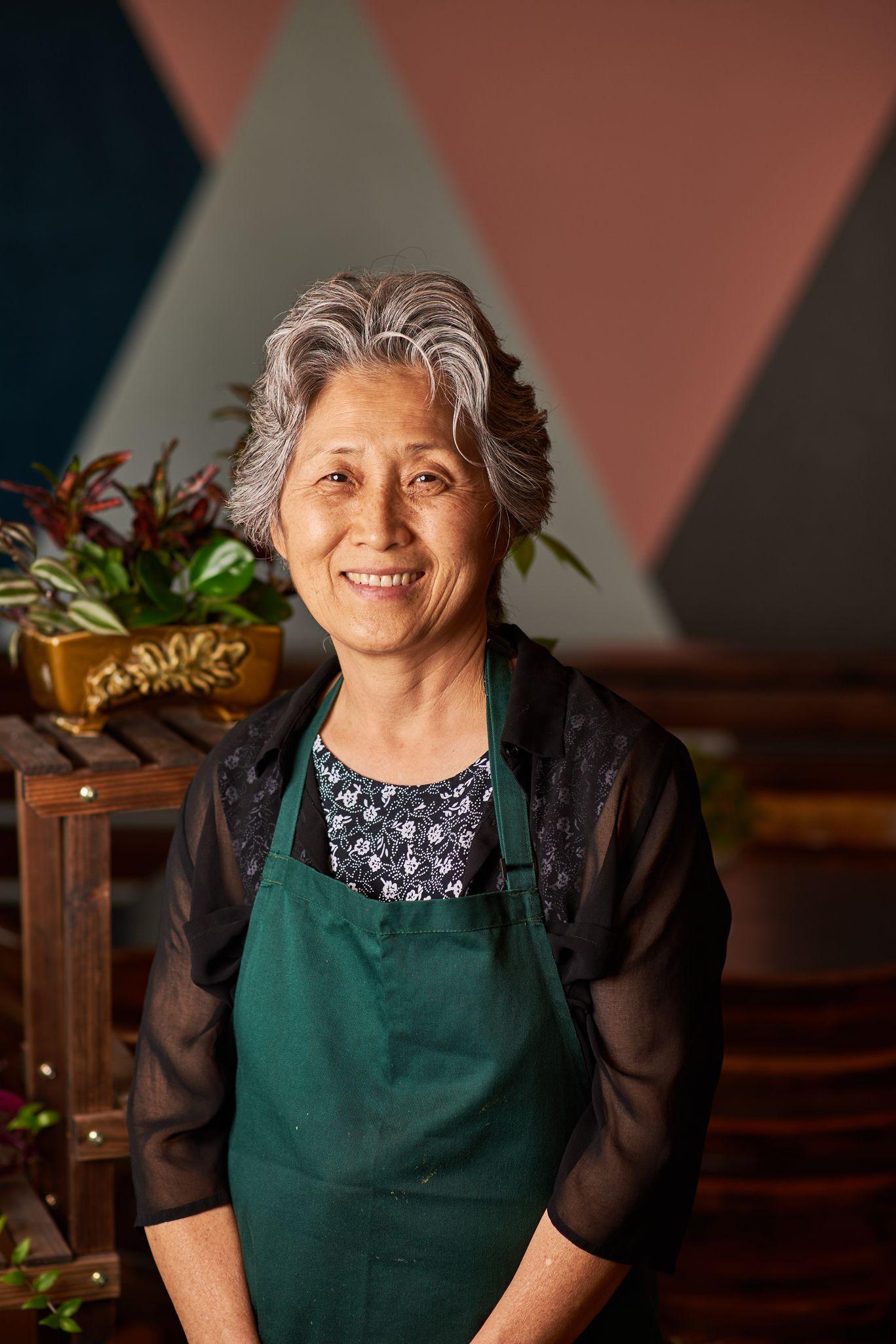 Chef in an apron smiling in her restaurant kitchen — Portrait photography, Austin A chef in an apron smiling in her restaurant kitchen.