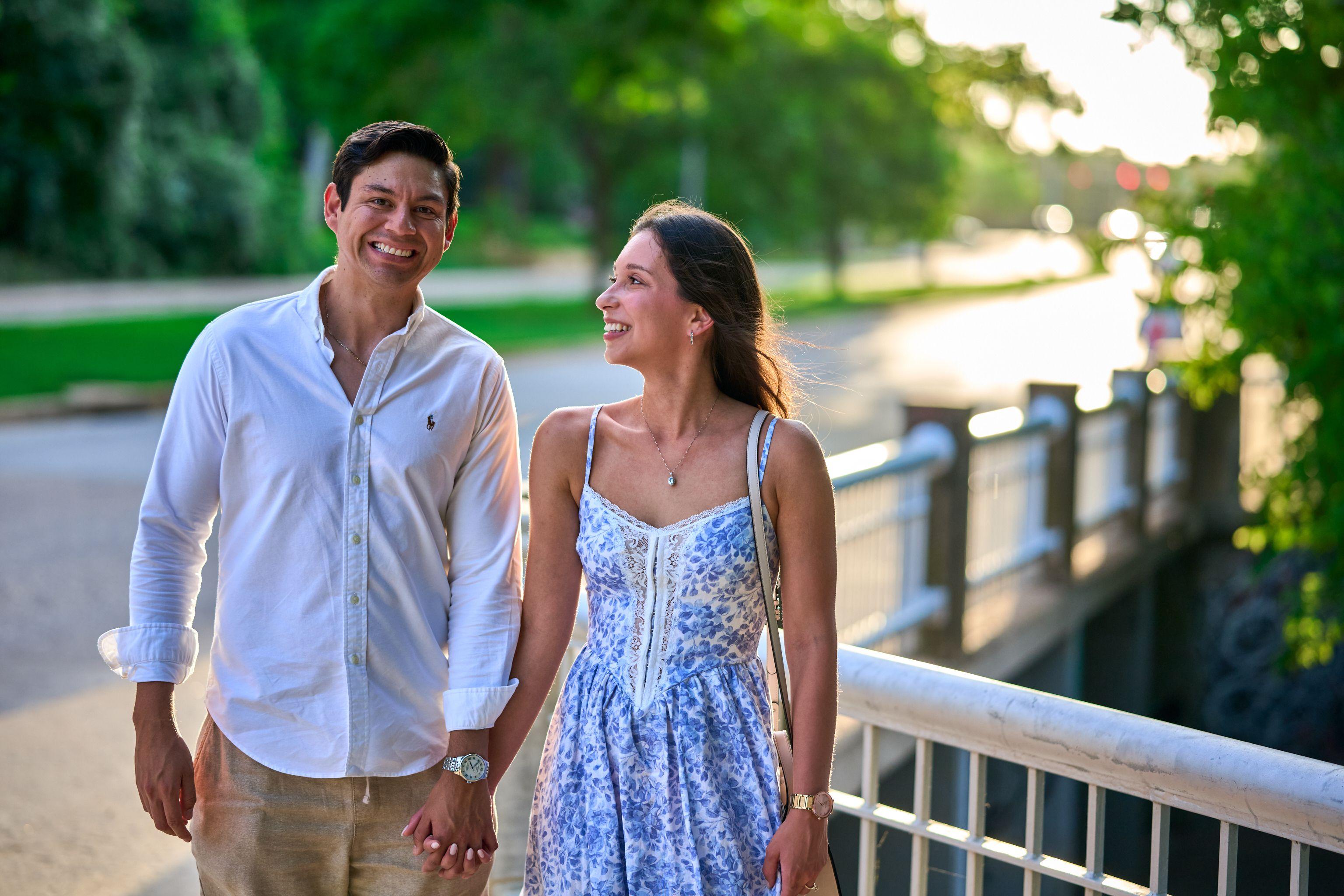 Couple laughing together on a lakeside boardwalk railing — Engagement & Proposals photography, Austin A couple laughing together on a lakeside boardwalk railing.