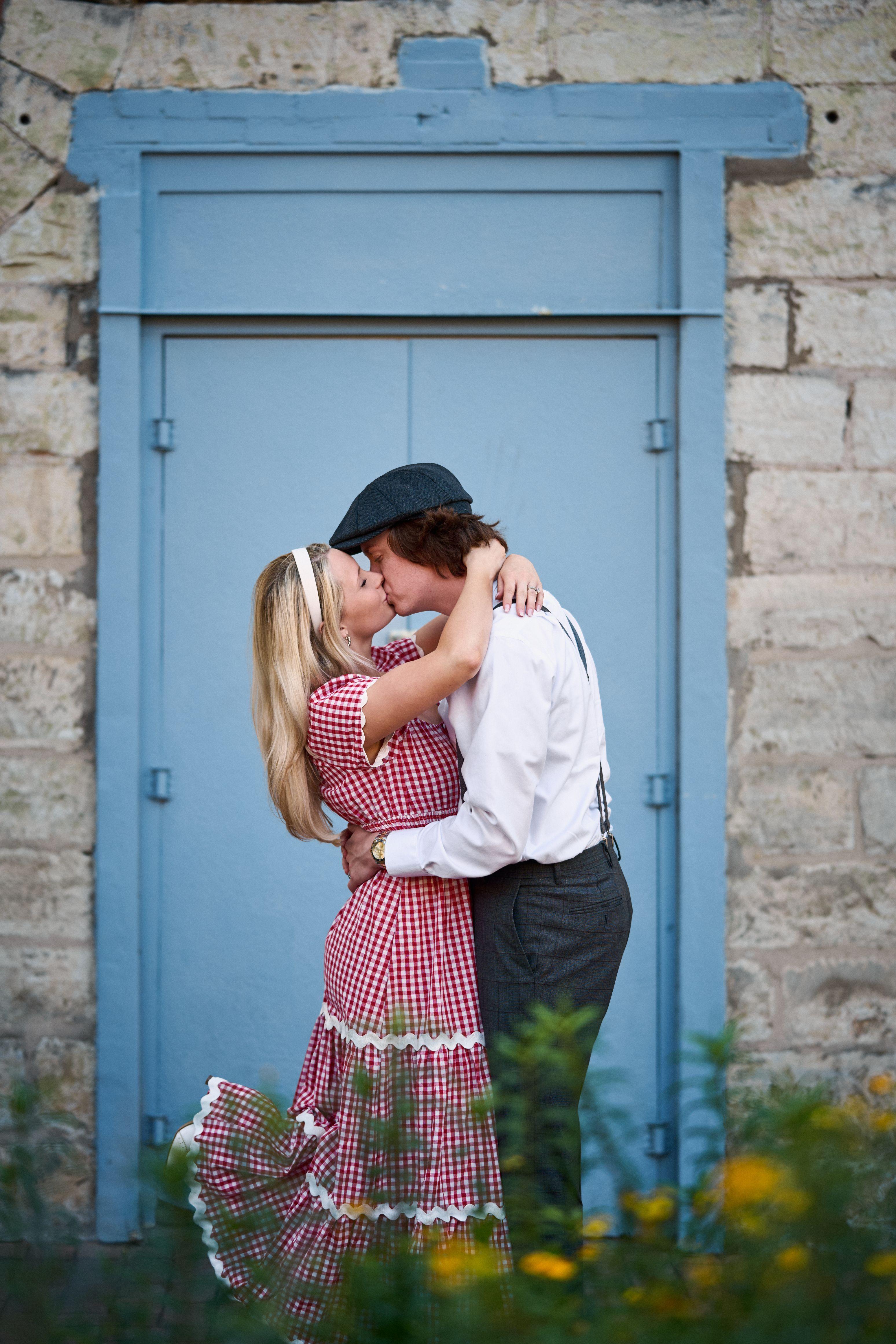 1940s-styled couple embracing in front of a pale blue door — Couples & Anniversary photography, Austin A 1940s-styled couple embracing in front of a pale blue door.