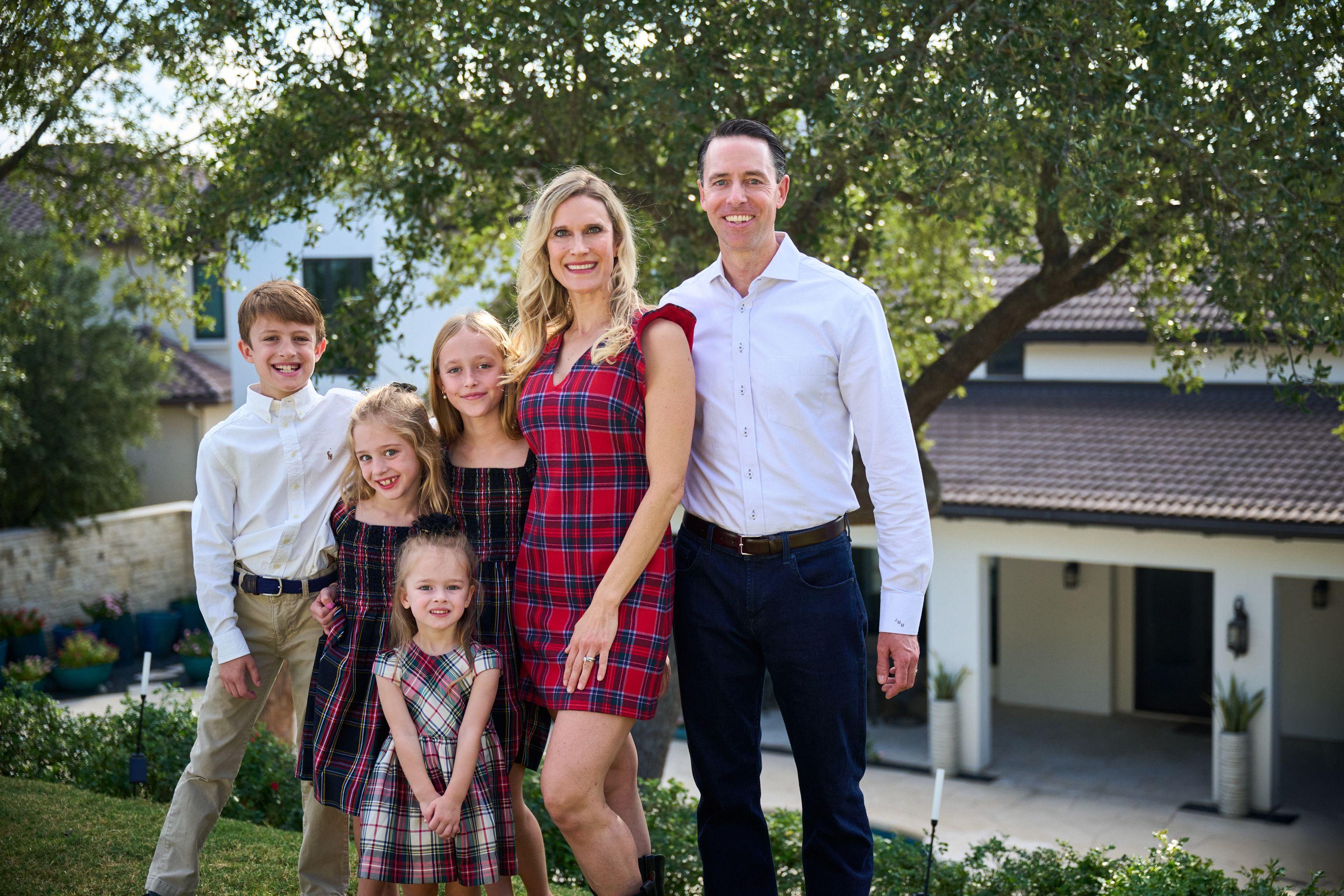 Family of four in red tartan posed together on a lawn at golden hour — Family Portraits photography, Austin A family of four in red tartan posed together on a lawn at golden hour.