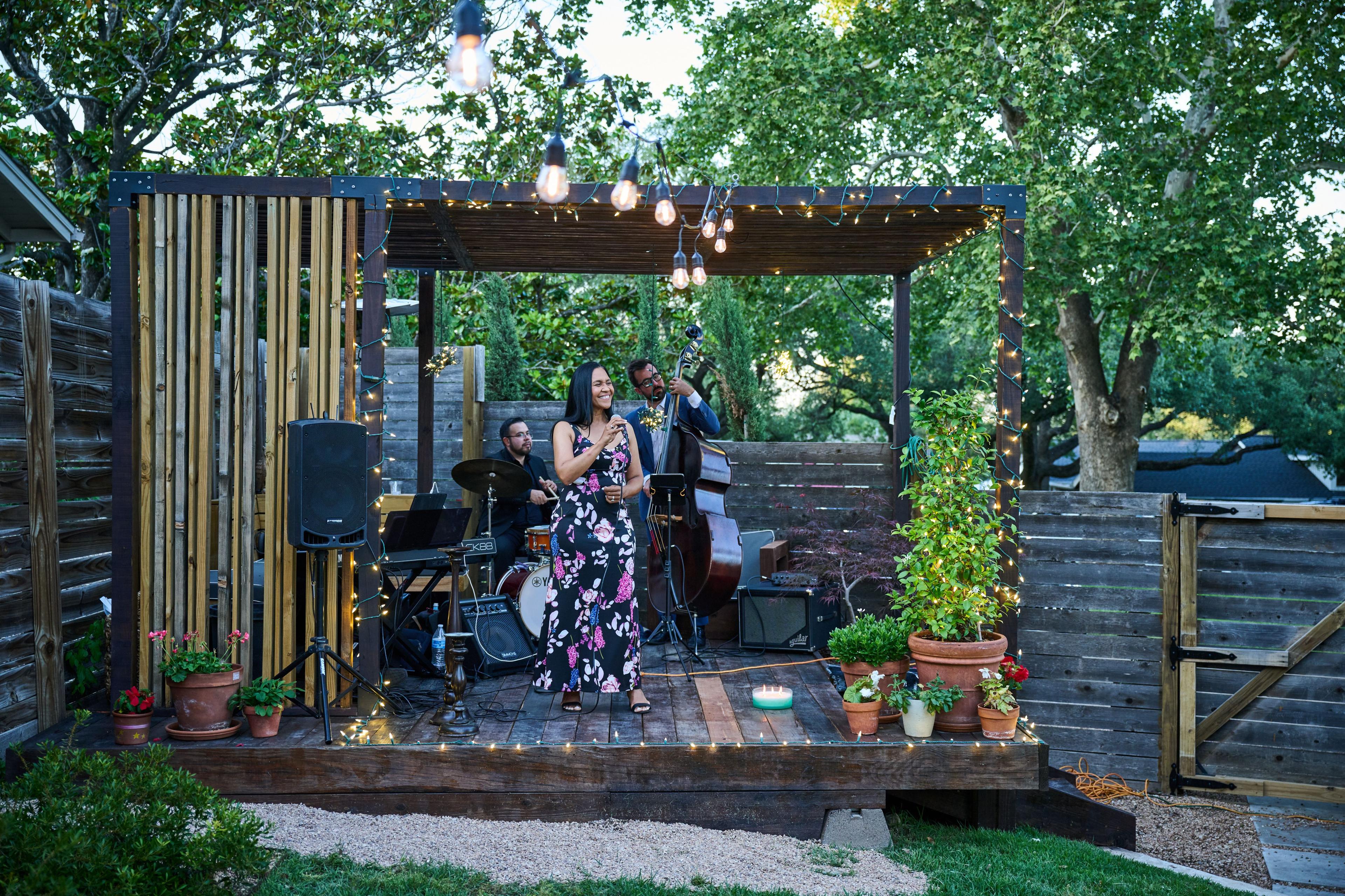 Small band performing on a string-lit outdoor patio stage — Live music photography, Austin A small band performing on a string-lit outdoor patio stage.