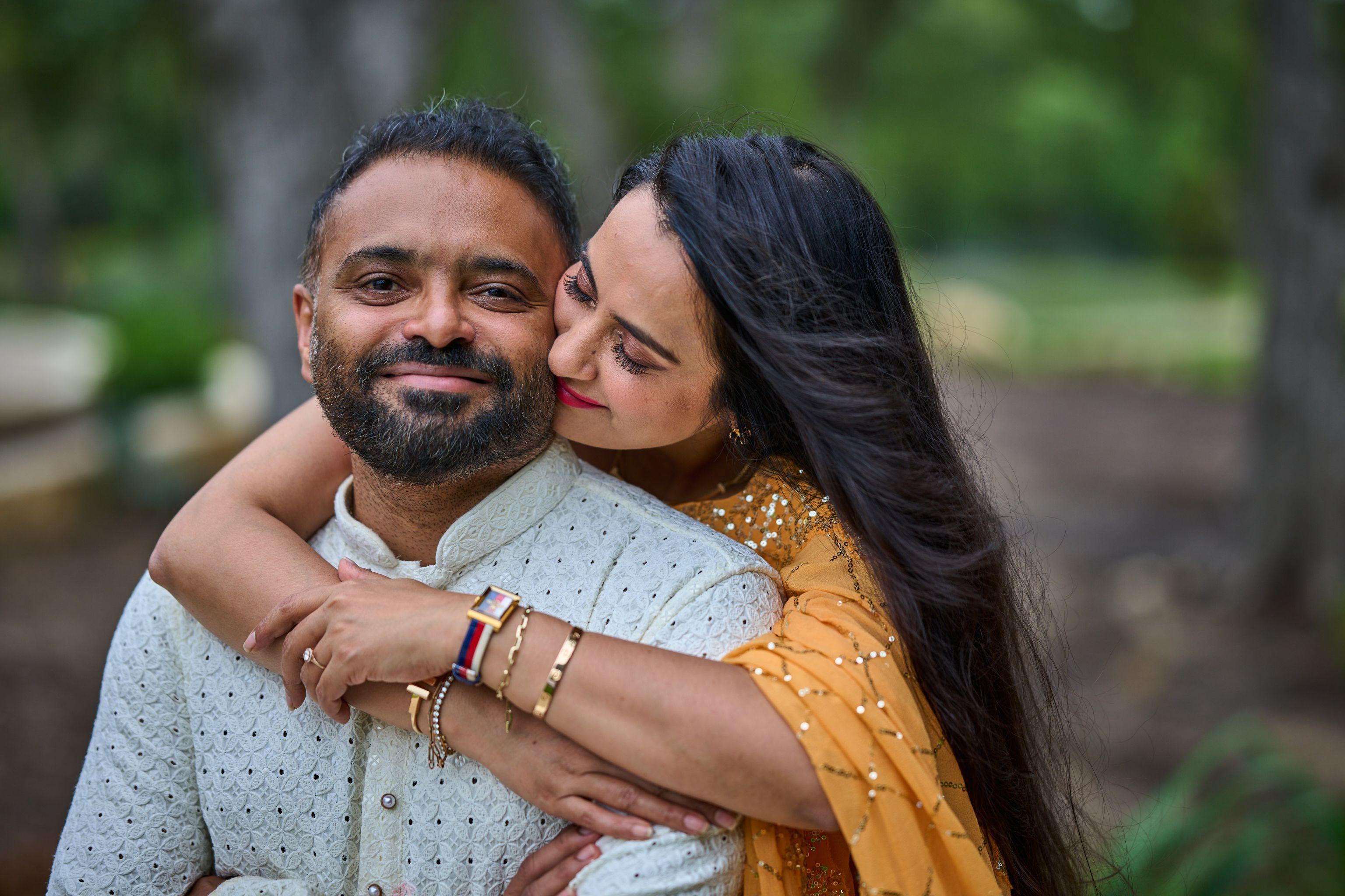 Couple in kurta and gold sari holding each other close, both smiling — Cedar Park Public Library photography, Austin A couple in kurta and gold sari holding each other close, both smiling.