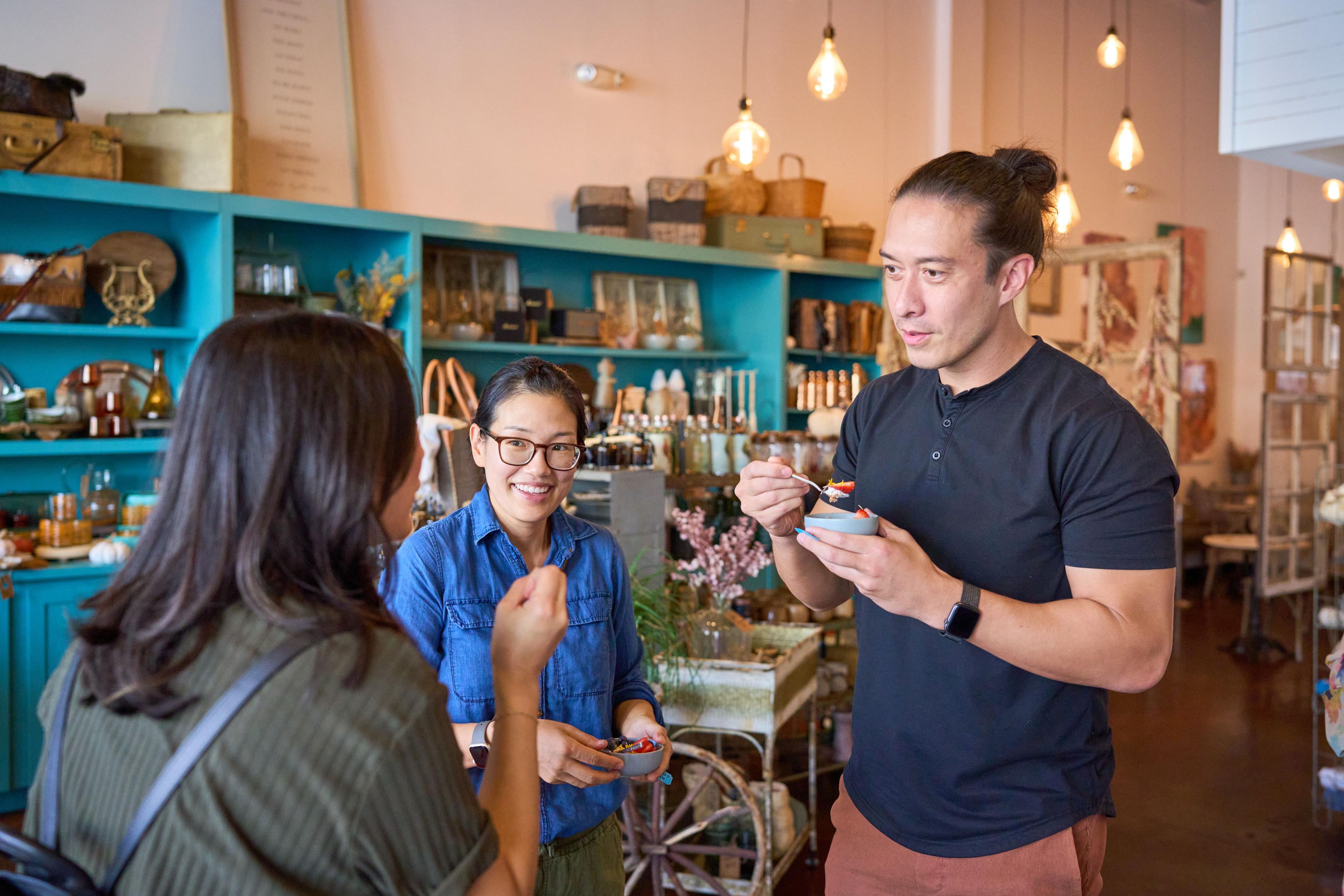 Guests tasting small plates together in a warmly lit shop-front event space — Business Parties photography, Austin Guests tasting small plates together in a warmly lit shop-front event space.