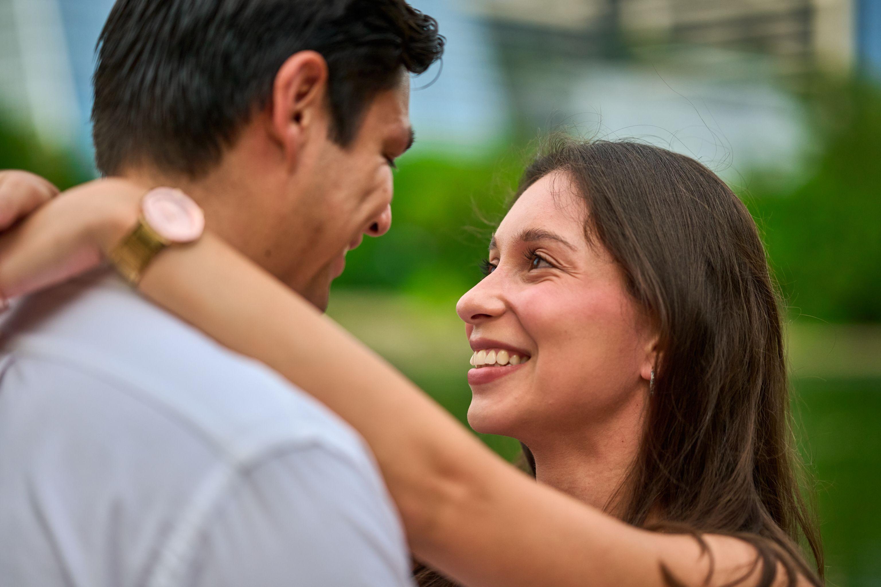 Close view of a couple embracing, her face lit as she smiles over his shoulder — Butler Metro Park photography, Austin A close view of a couple embracing, her face lit as she smiles over his shoulder.