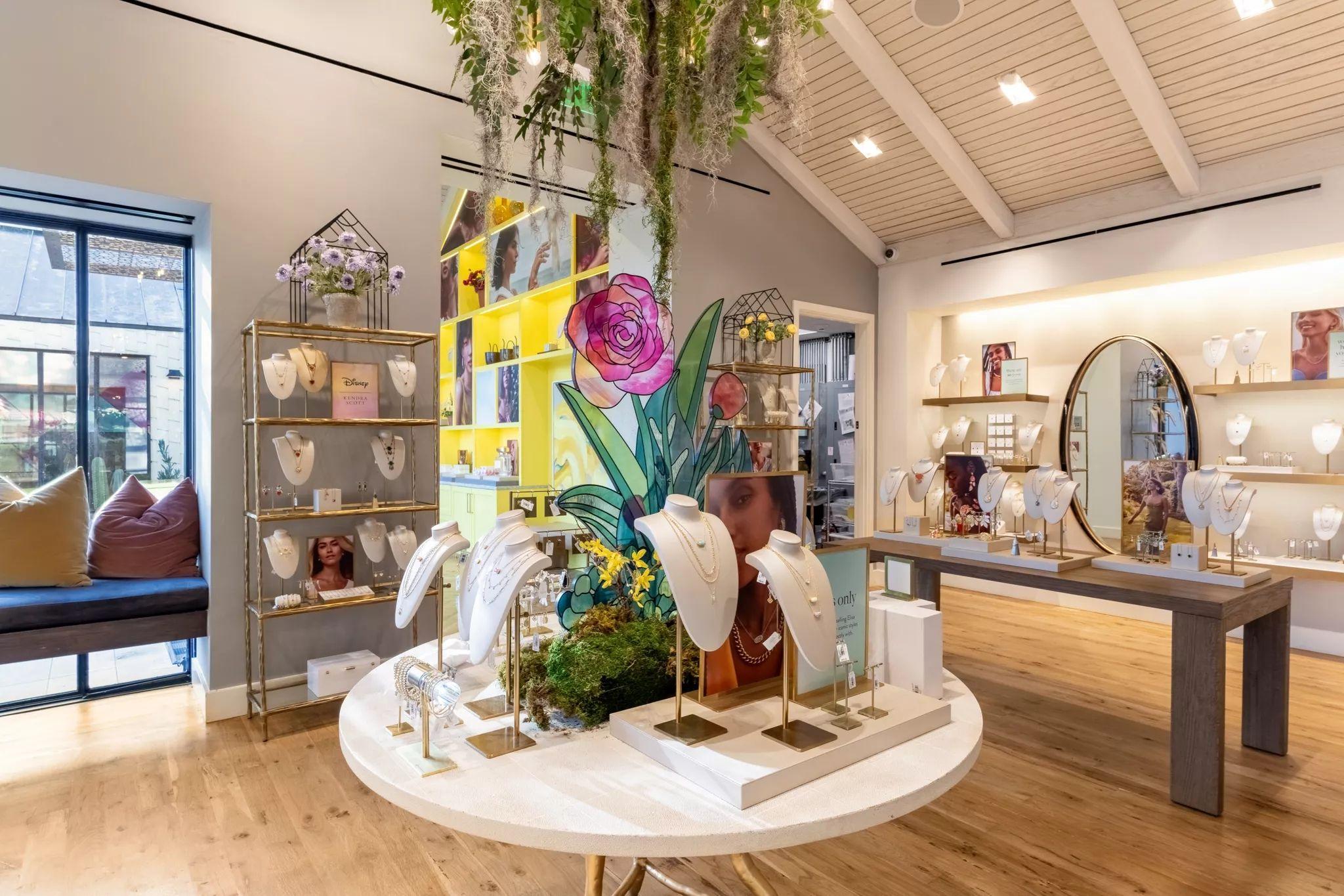 Jewelry display table crowned with an oversized painted flower and yellow shelving — Brand Collaborations photography, Austin A jewelry display table crowned with an oversized painted flower and yellow shelving in a Kendra Scott store.