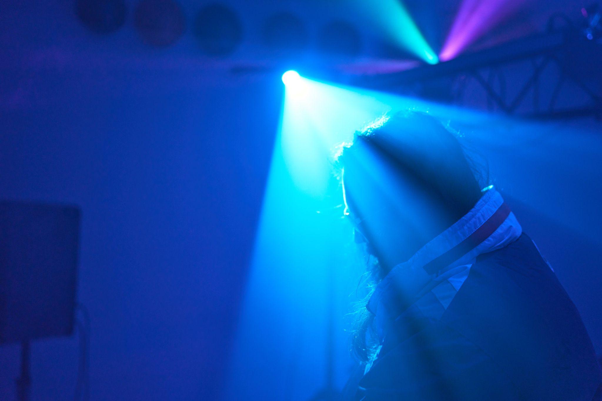 Blue stage lighting cutting through haze in a dark club — Party & nightlife photography, Austin Blue stage lighting cutting through haze in a dark club.