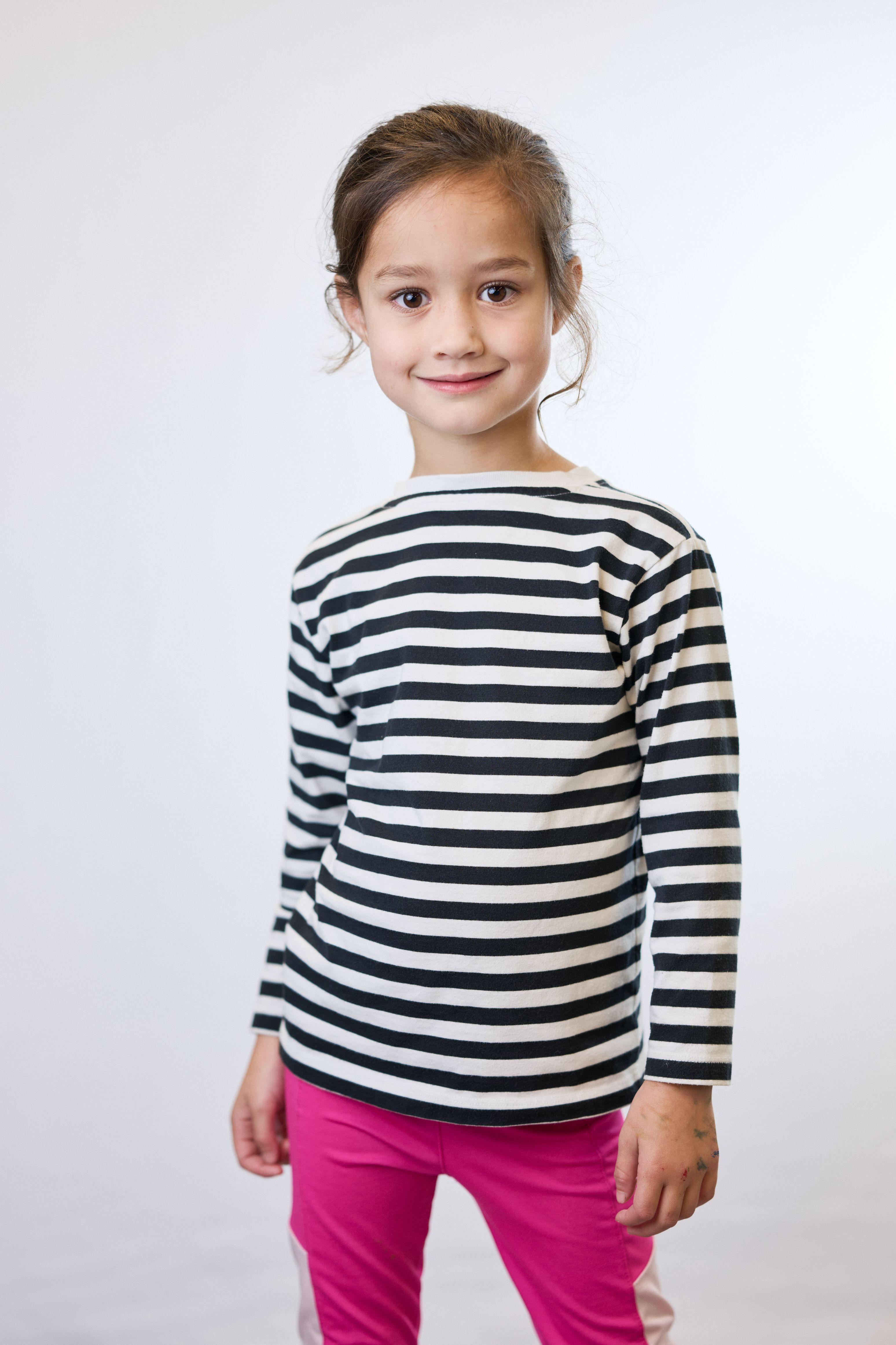 Girl in a black and white striped top and pink trousers on white seamless — Commercial photo studio, Austin Girl in a black and white striped top and pink trousers on white seamless
