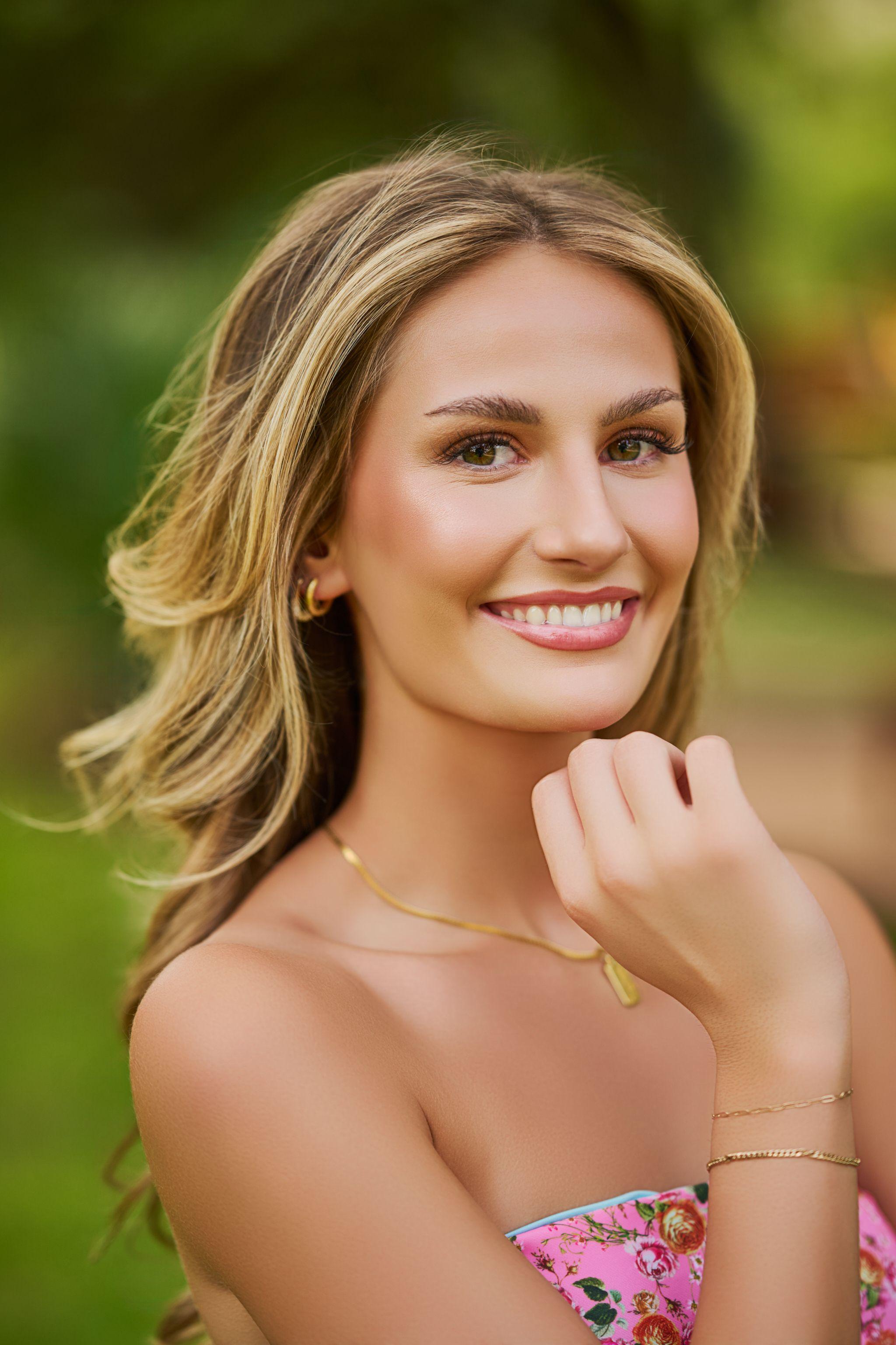 Close portrait of a model with wind-blown hair, smiling in a green park — Photo retouching, Austin A close portrait of a model with wind-blown hair, smiling in a green park.