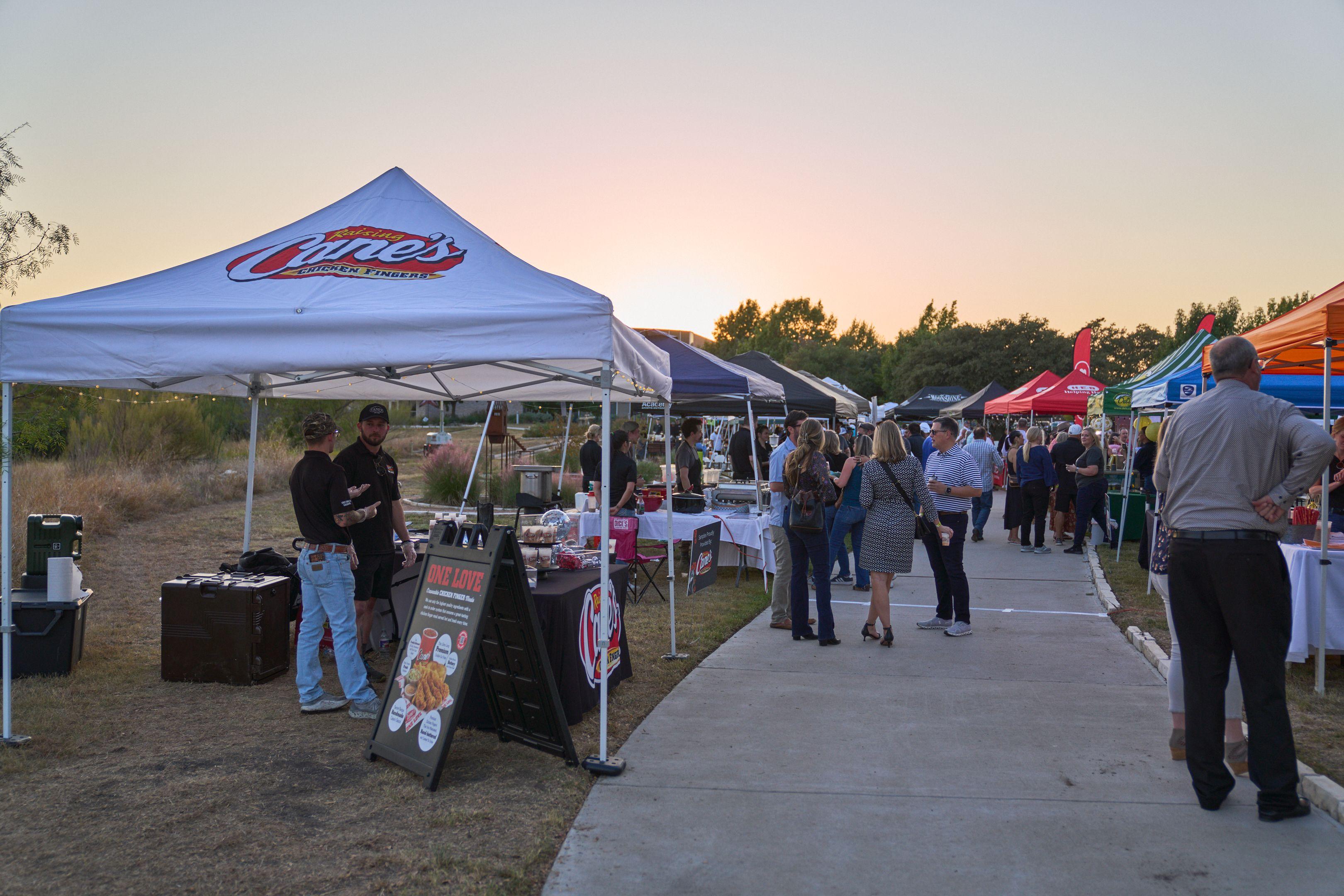 Vendor tents lining a festival midway at sunset — Festival photography, Austin Vendor tents lining a festival midway at sunset.