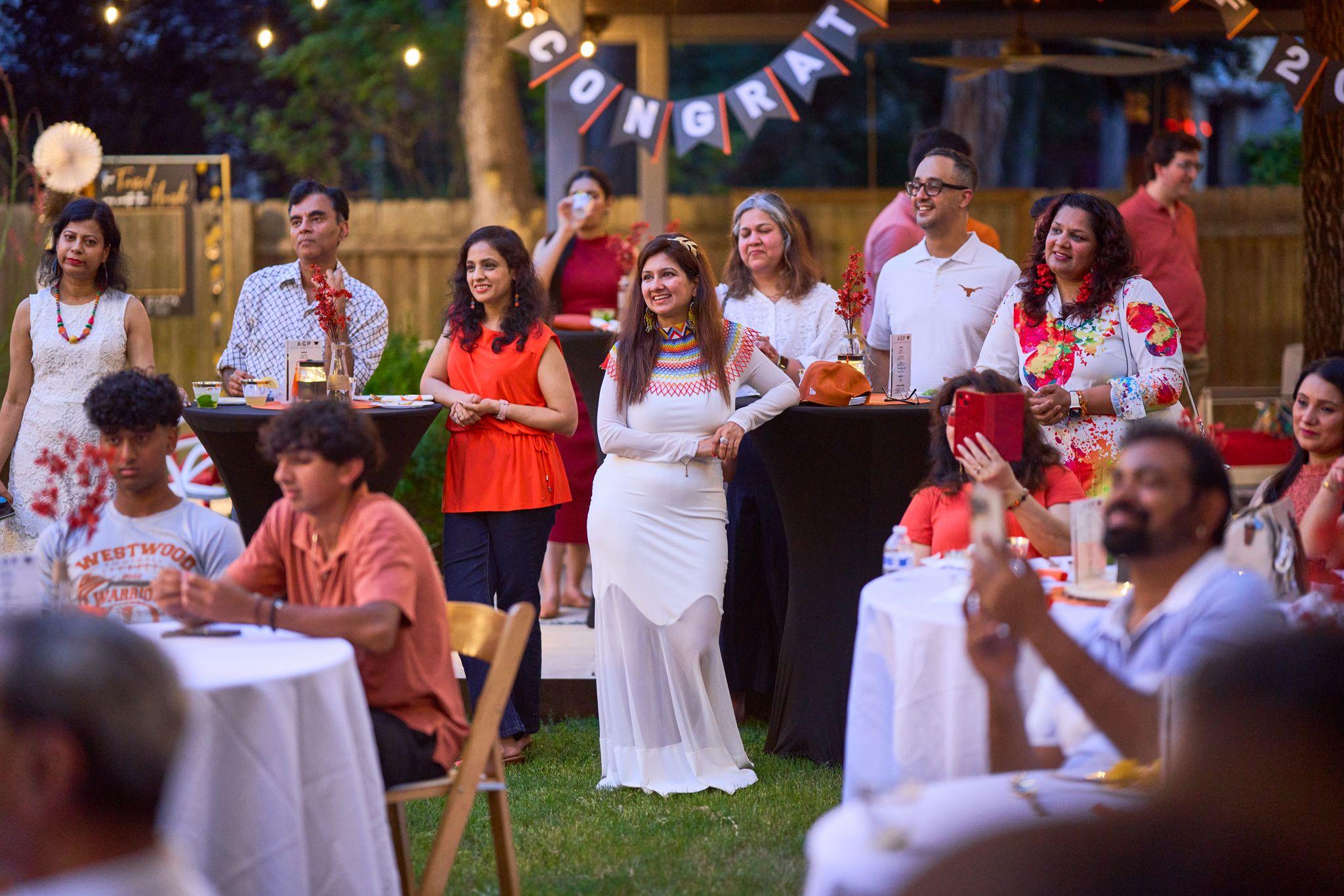 Family serving food at a backyard graduation party under a 'Congrats' banner — Graduation & Prom photography, Austin Family serving food at a backyard graduation party under a 'Congrats' banner.