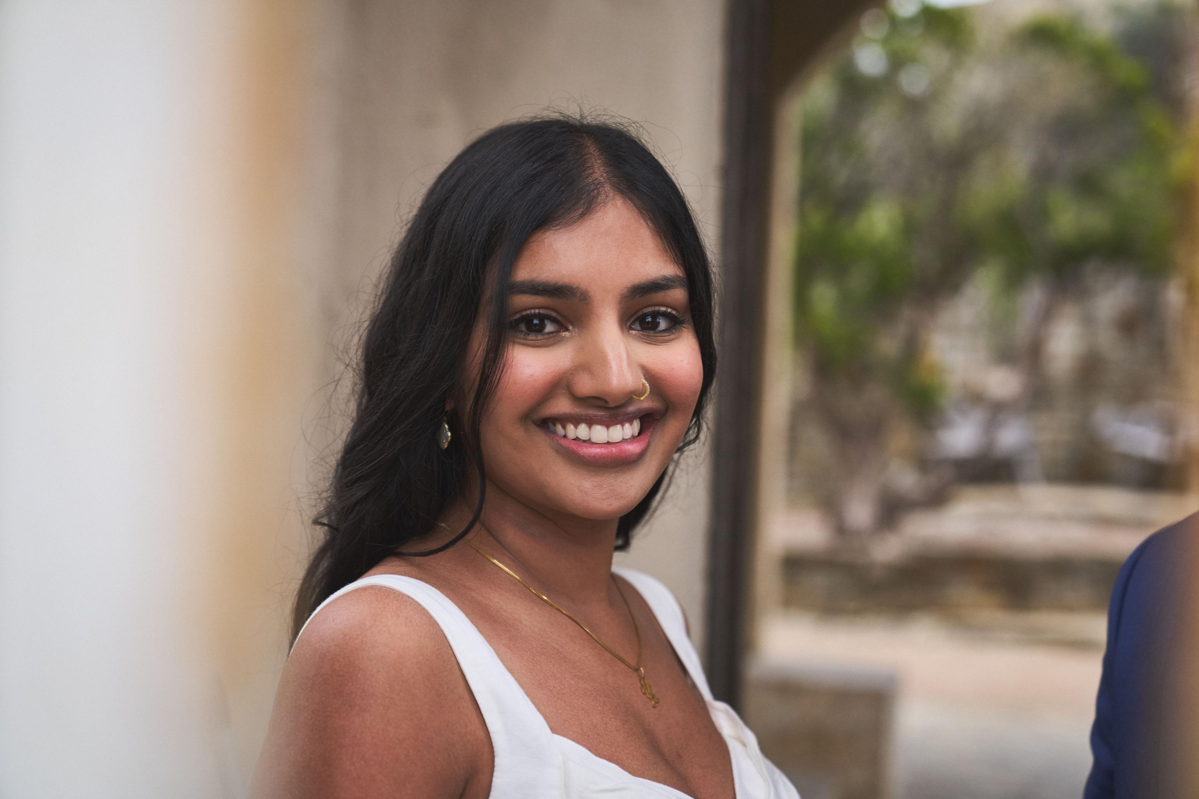 Portrait of a bride in a white dress smiling in front of a stone archway — Elopements photography, Austin A portrait of a bride in a white dress smiling in front of a stone archway.