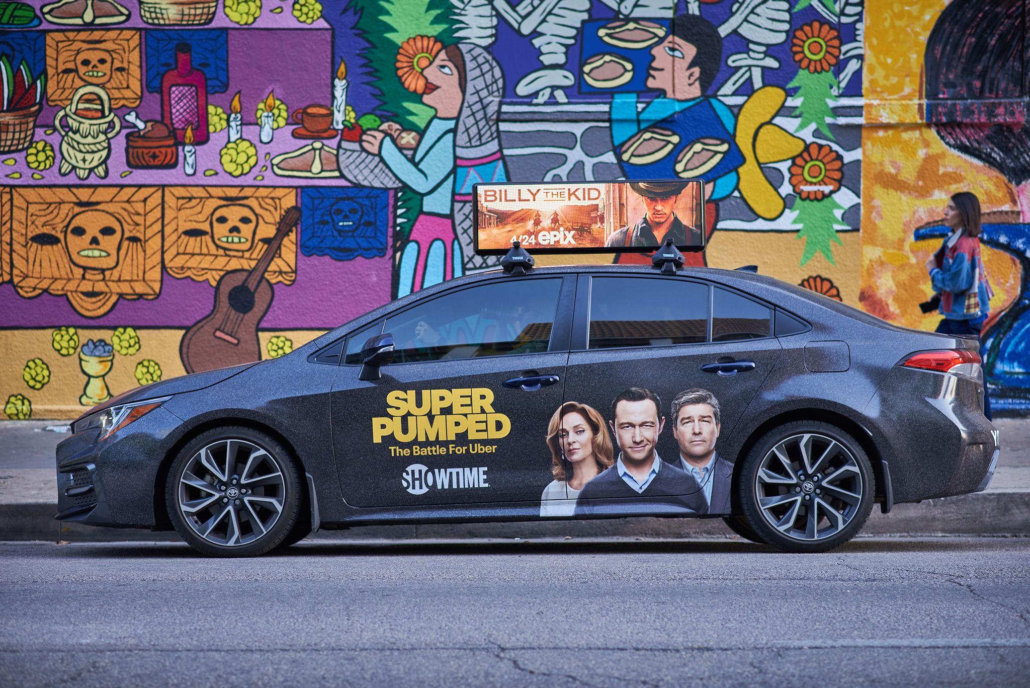 Car carrying a rooftop digital screen advertising the Showtime series Super Pumped, parked — Brand Collaborations photography, Austin A car carrying a rooftop digital screen advertising the Showtime series Super Pumped, parked in front of a colorful Austin mural.