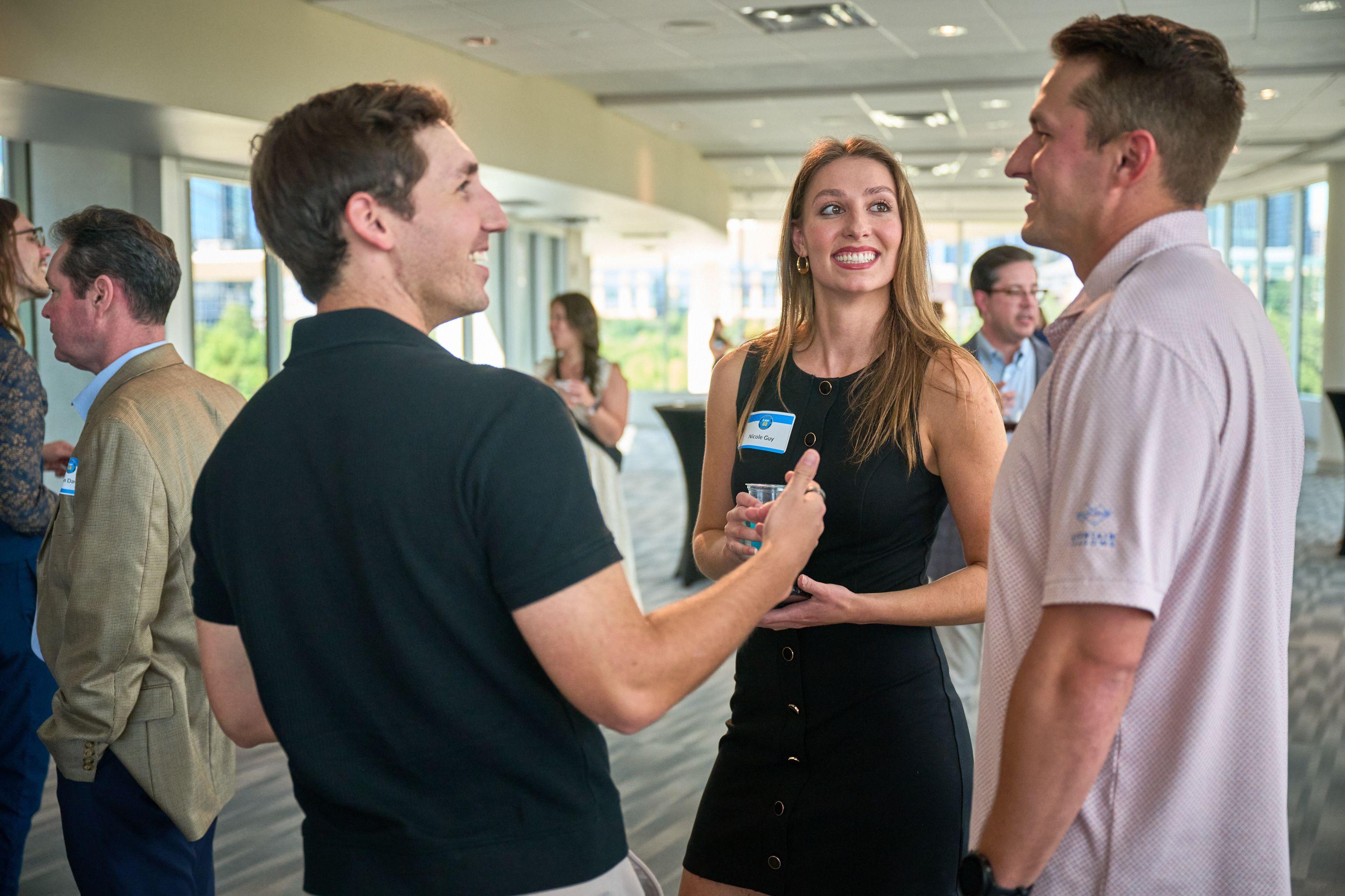 Two delegates laughing mid-conversation at a bright daytime conference reception — Conventions & Tradeshows photography, Austin Two delegates laughing mid-conversation at a bright daytime conference reception.