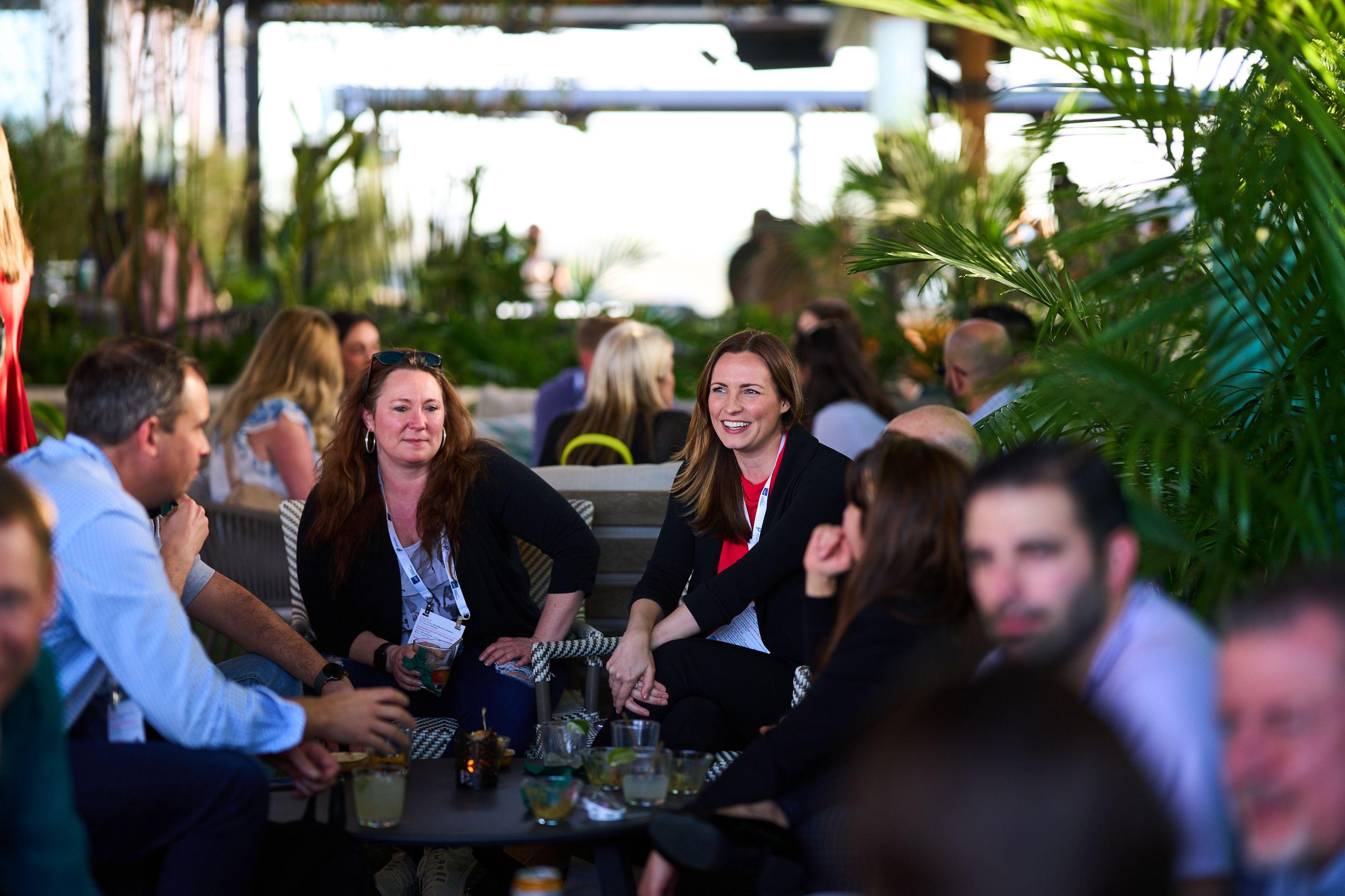 Group of women laughing together around a rooftop table at golden hour — Business Parties photography, Austin A group of women laughing together around a rooftop table at golden hour.