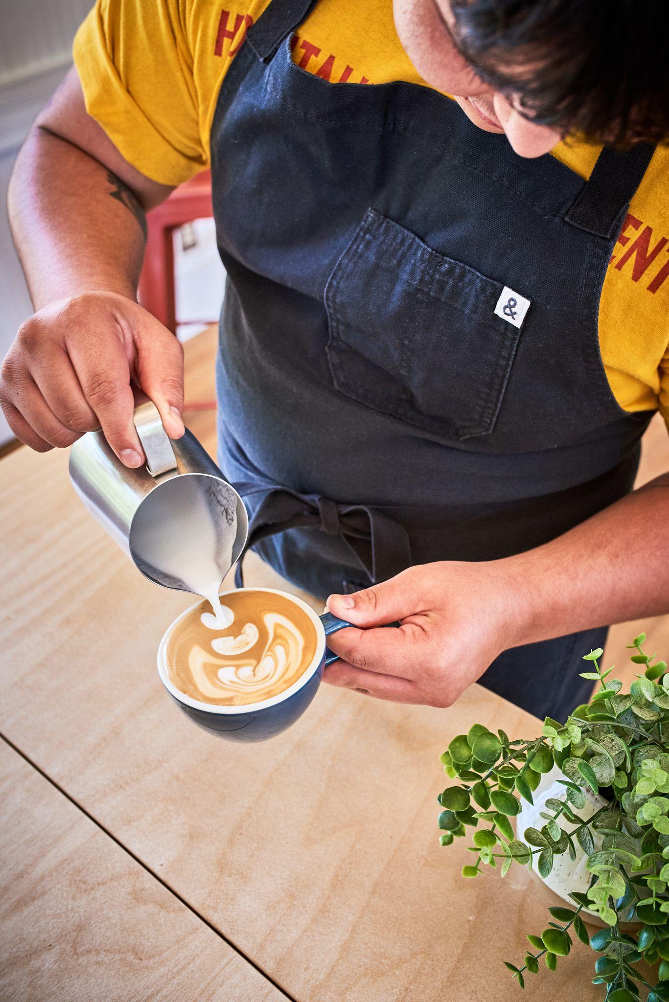Barista pouring milk into a latte to finish the rosetta — Food & restaurant photography, Austin A barista pouring milk into a latte to finish the rosetta.