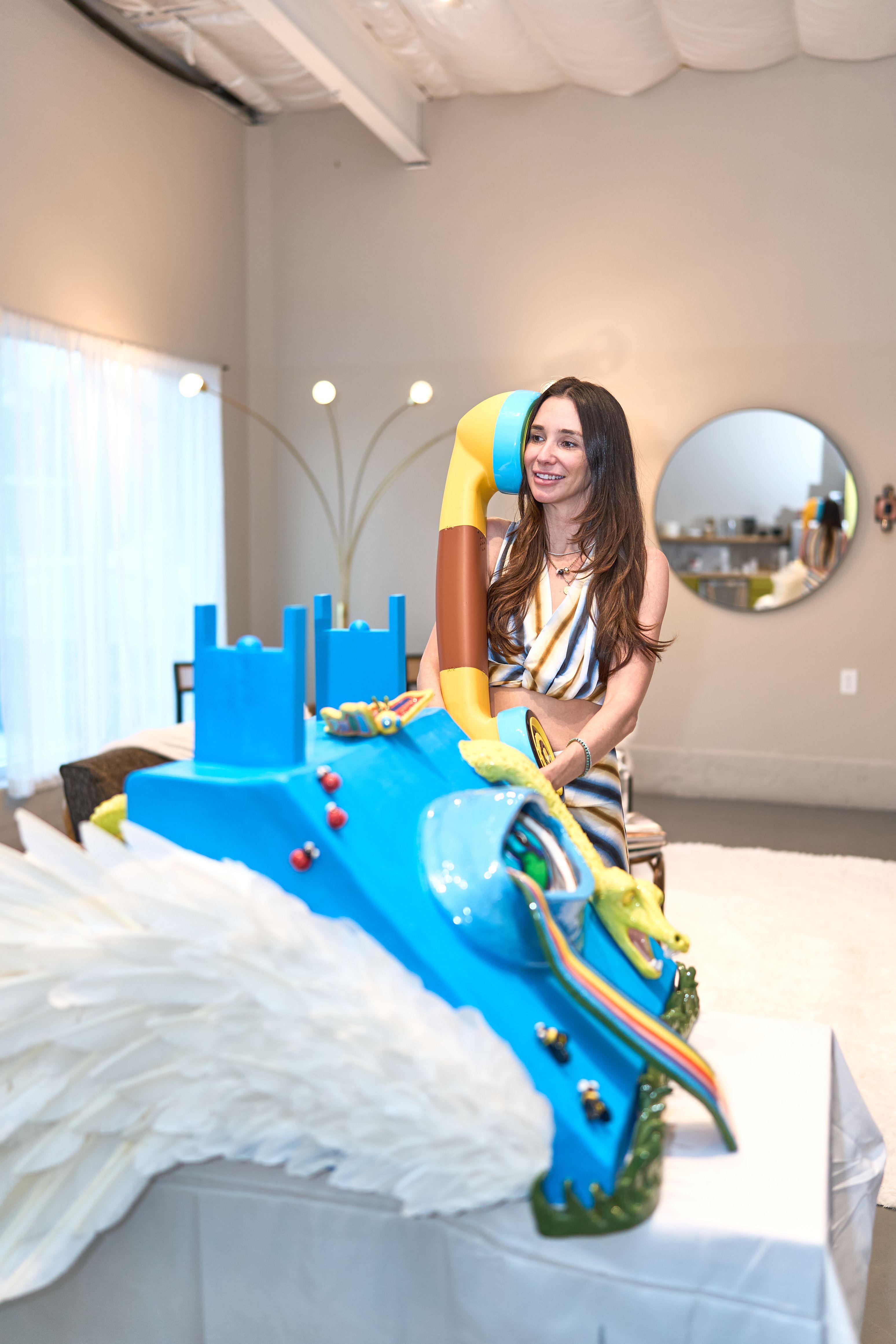 Artist seated on a large blue and white sculpture of a horse in a bright white-walled room — Artwork & archival photography, Austin Artist seated on a large blue and white sculpture of a horse in a bright white-walled room