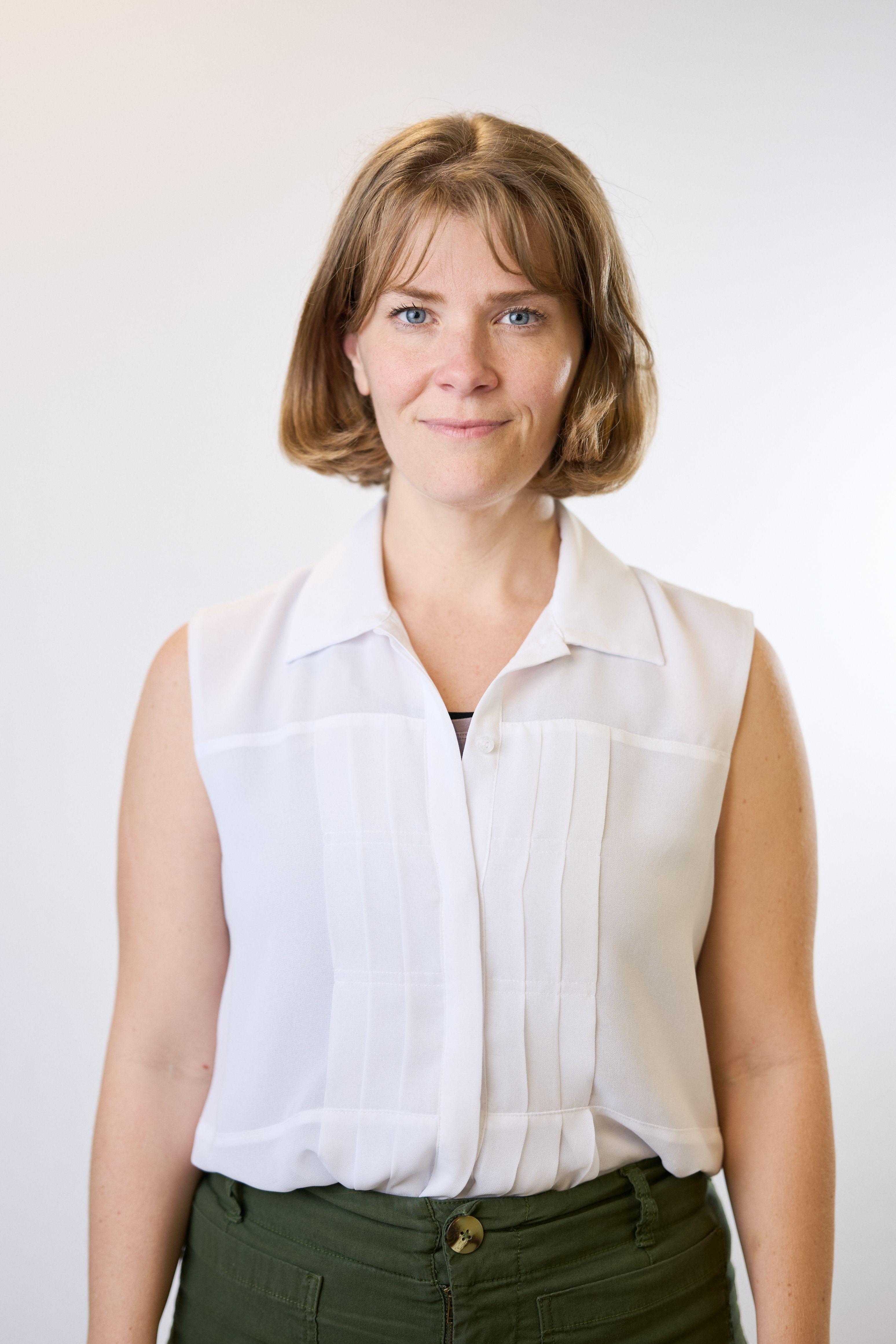 Woman with a short bob in a sleeveless white blouse against a light studio background — Commercial photo studio, Austin Woman with a short bob in a sleeveless white blouse against a light studio background